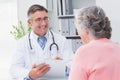 Smiling doctor writing prescriptions for patient Royalty Free Stock Photo