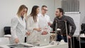 Smiling doctors giving pills to male patient on crutches and cheering him up Royalty Free Stock Photo