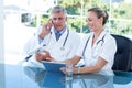 Smiling doctors working together on tablet Royalty Free Stock Photo