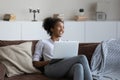 Smiling dreamy African American young woman distracted from laptop Royalty Free Stock Photo