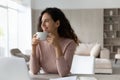 Smiling dreamy businesswoman drinking tea or coffee at workplace Royalty Free Stock Photo