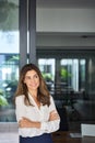 Smiling Latin professional mature business woman looking away in office.