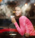 Smiling dreamy thoughtful woman in restaurant with cup of coffee, joyfully looking out, view through window with reflections Royalty Free Stock Photo