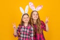 smiling easter children in bunny ears on yellow background. peace