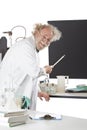 Smiling eccentric scientist points to blackboard