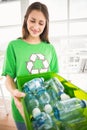 Smiling eco-minded brunette showing recycling box