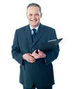 Smiling elderly businessman holding clipboard