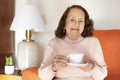 Smiling elderly Caucasian woman drinking coffee or tea at home Royalty Free Stock Photo