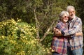 Smiling elderly couple in the forest hugging each other enjoying the spring and flowering. Two retirees who love a healthy Royalty Free Stock Photo