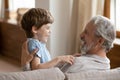 Smiling elderly grandfather playing with small grandson