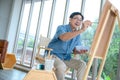 Smiling elderly man painting a vacation at home. Royalty Free Stock Photo