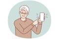 Smiling elderly man point at cell screen