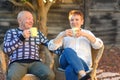 Happy senior old couple drink coffee by the park on sunny day. Royalty Free Stock Photo