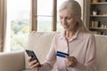 Smiling elderly retired woman do e-shopping online