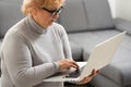 Smiling elderly senior woman with laptop at home