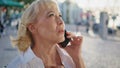 Smiling elderly woman calling mobile phone on street close up. Pensioner talking Royalty Free Stock Photo