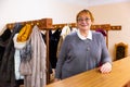 Smiling elderly woman checkroom attendant working in theater