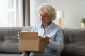 Smiling elderly woman customer receive post shipment parcel at home