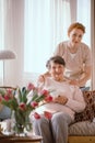 Smiling elderly woman drinking tea with her caregiver in the retirement home Royalty Free Stock Photo