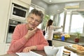 Smiling elderly woman with home carer in the background