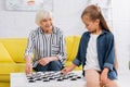 Smiling elderly woman playing checkers game Royalty Free Stock Photo