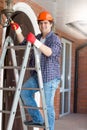 Smiling electrician standing on stepladder and repairing outdoor Royalty Free Stock Photo
