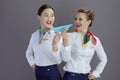 smiling elegant female air hostesses against gray background Royalty Free Stock Photo