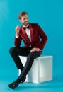 Smiling elegant man wearing red velvet tuxedo and looking to side Royalty Free Stock Photo