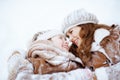 Smiling elegant mother and child laying in snow Royalty Free Stock Photo