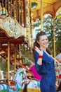 Smiling elegant tourist woman riding on carousel and waving