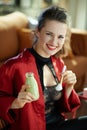 Smiling elegant woman with bottle of yoghurt and cosmetic brush