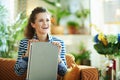 Smiling elegant woman holding laptop while sitting on divan Royalty Free Stock Photo