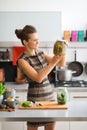 Smiling and elegant woman in kitchen holding up jar of pickles Royalty Free Stock Photo