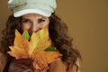 Smiling elegant woman in scarf isolated on brown background Royalty Free Stock Photo