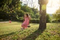 Smiling elementary age Caucasian little child playing on swing at the playground. Happy girl having fun on swing outdoor Royalty Free Stock Photo