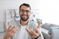 Smiling emotional adult european male with beard in glasses looks at camera and shooting video for blog