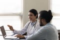 Smiling empathetic Indian practitioner showing laptop screen to male patient Royalty Free Stock Photo