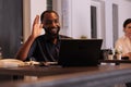 Smiling employee talking on videoconference with teamlead, waving hi