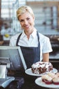 Smiling employee using calculator on counter