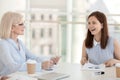 Smiling employees discuss paperwork statistics at company meeting