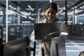 Smiling engineer using laptop in data center to oversee hardware Royalty Free Stock Photo
