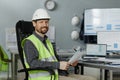 Smiling engineer wearing hardhat at workplace in office and looking at camera Royalty Free Stock Photo