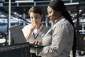 Smiling engineering team using laptop in data center, running scripts Royalty Free Stock Photo