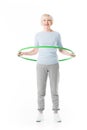 Smiling enior sportswoman doing hula hoop exercise