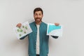 Smiling entrepreneur or salesman showing his charts sales and business plan on white background Royalty Free Stock Photo