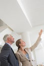 Smiling estate agent showing ceiling to potential buyer