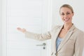 Smiling estate agent showing door to camera