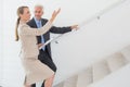 Smiling estate agent showing stairs to potential buyer