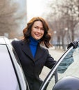 Smiling european middle-aged woman sits in the car