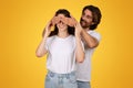 Smiling man surprises a woman by covering her eyes from behind with his hands Royalty Free Stock Photo